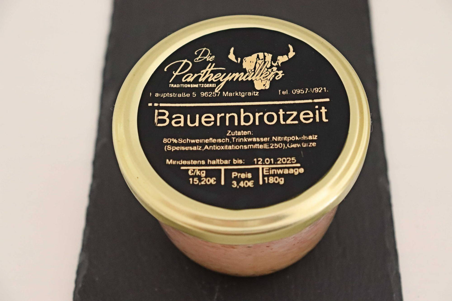 Ein Glas Bauernbrotzeit mit goldenem Deckel auf schwarzem Untegrund von der Marke Partheymüller