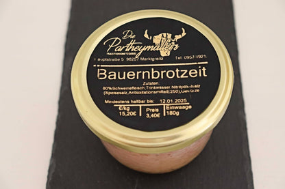 Ein Glas Bauernbrotzeit mit goldenem Deckel auf schwarzem Untegrund von der Marke Partheymüller