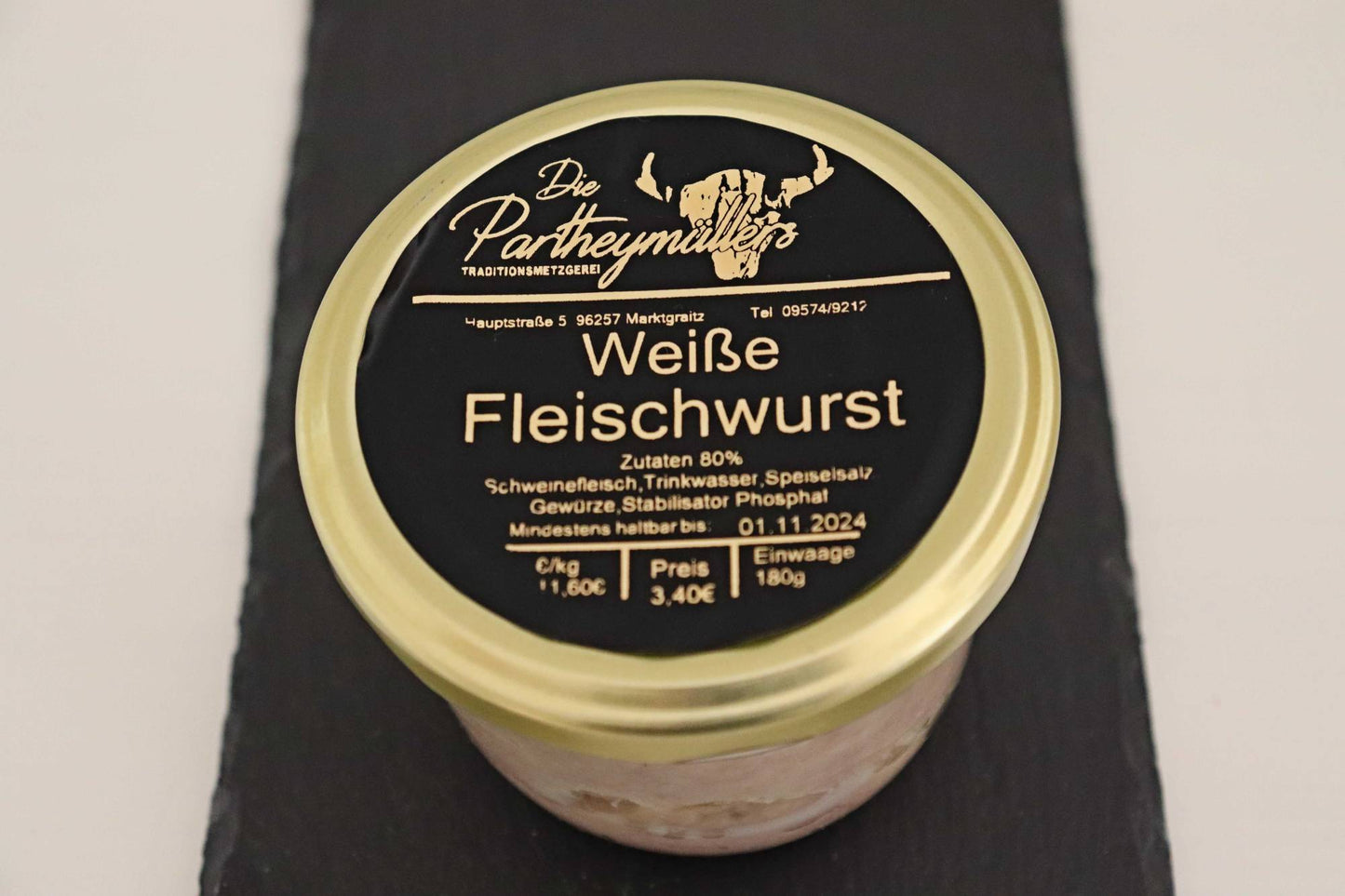 Ein Glas mit weisser Fleischwurst von der Firma Partheymüller, mit schwarzem Etikett auf goldenem Deckel.